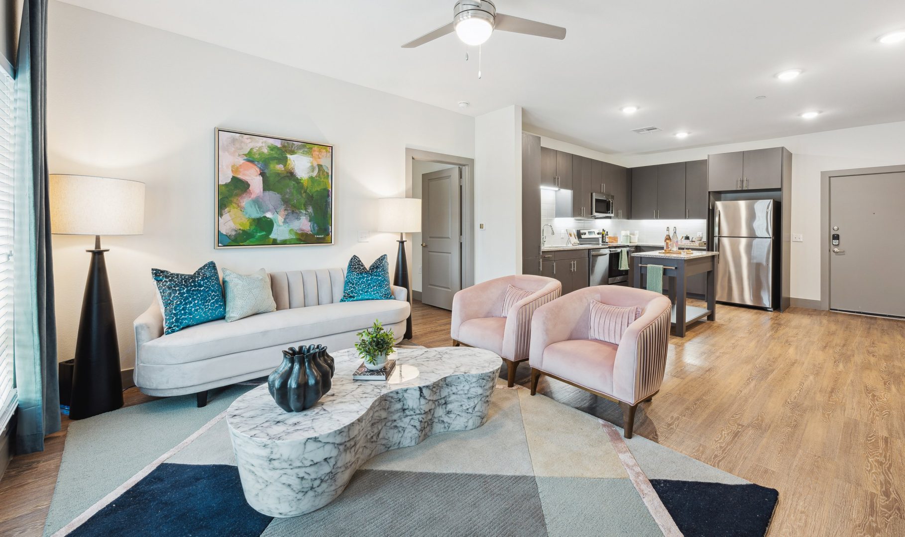 a living room with a couch, coffee table and chairs at The BroadVue