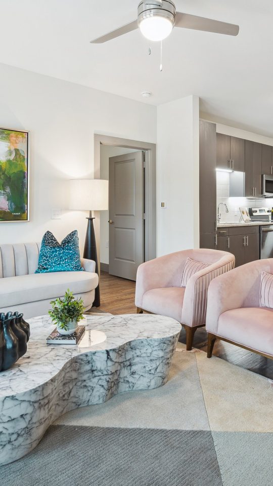 a living room with a couch, coffee table and chairs at The BroadVue
